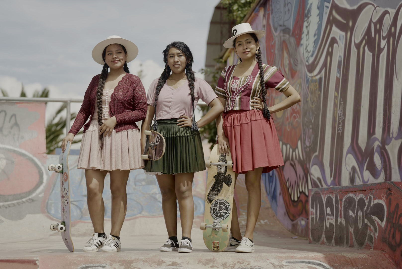 Three young Indigenous skaters posing with their boards