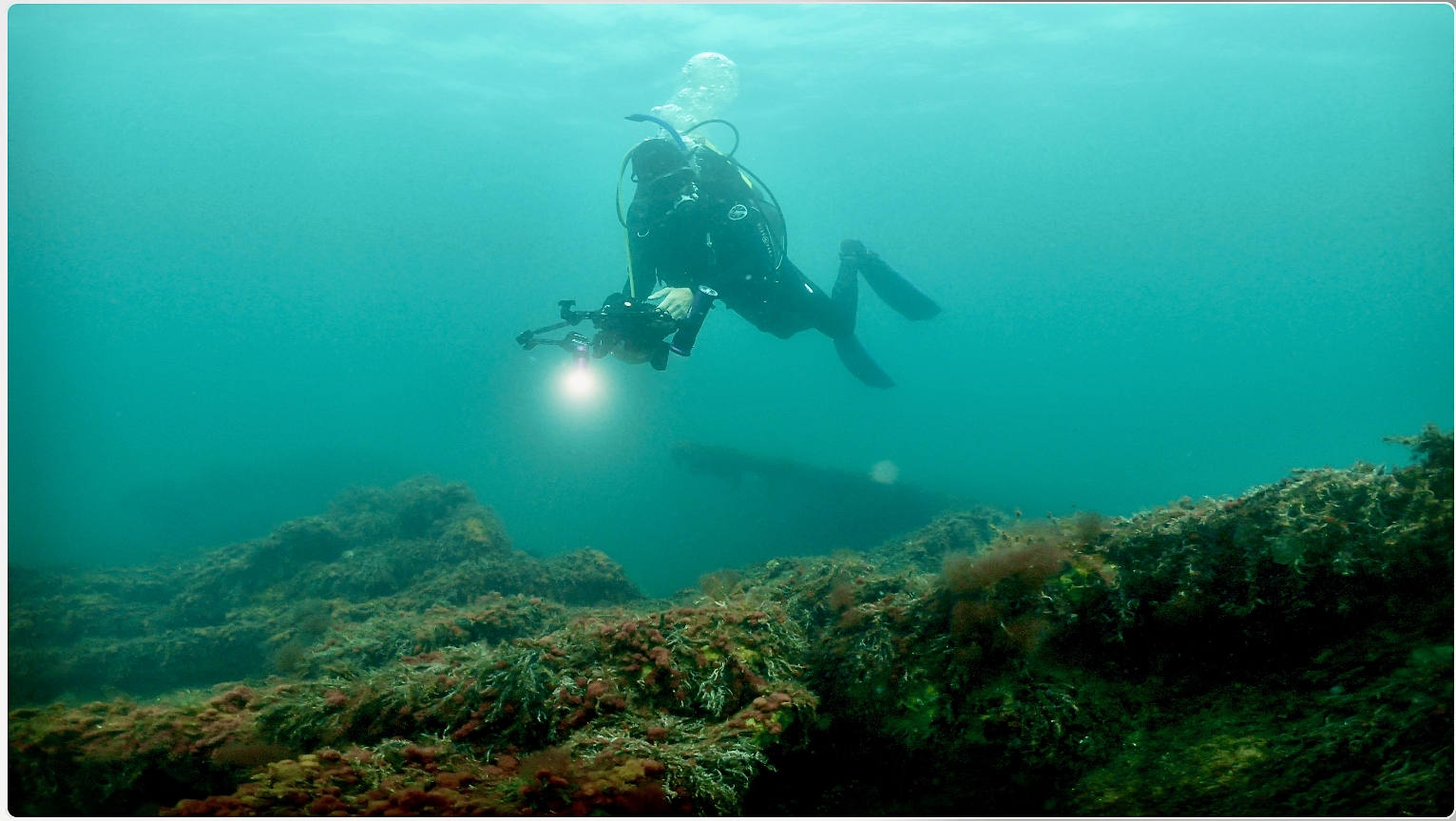 Underwater diver filming with a light