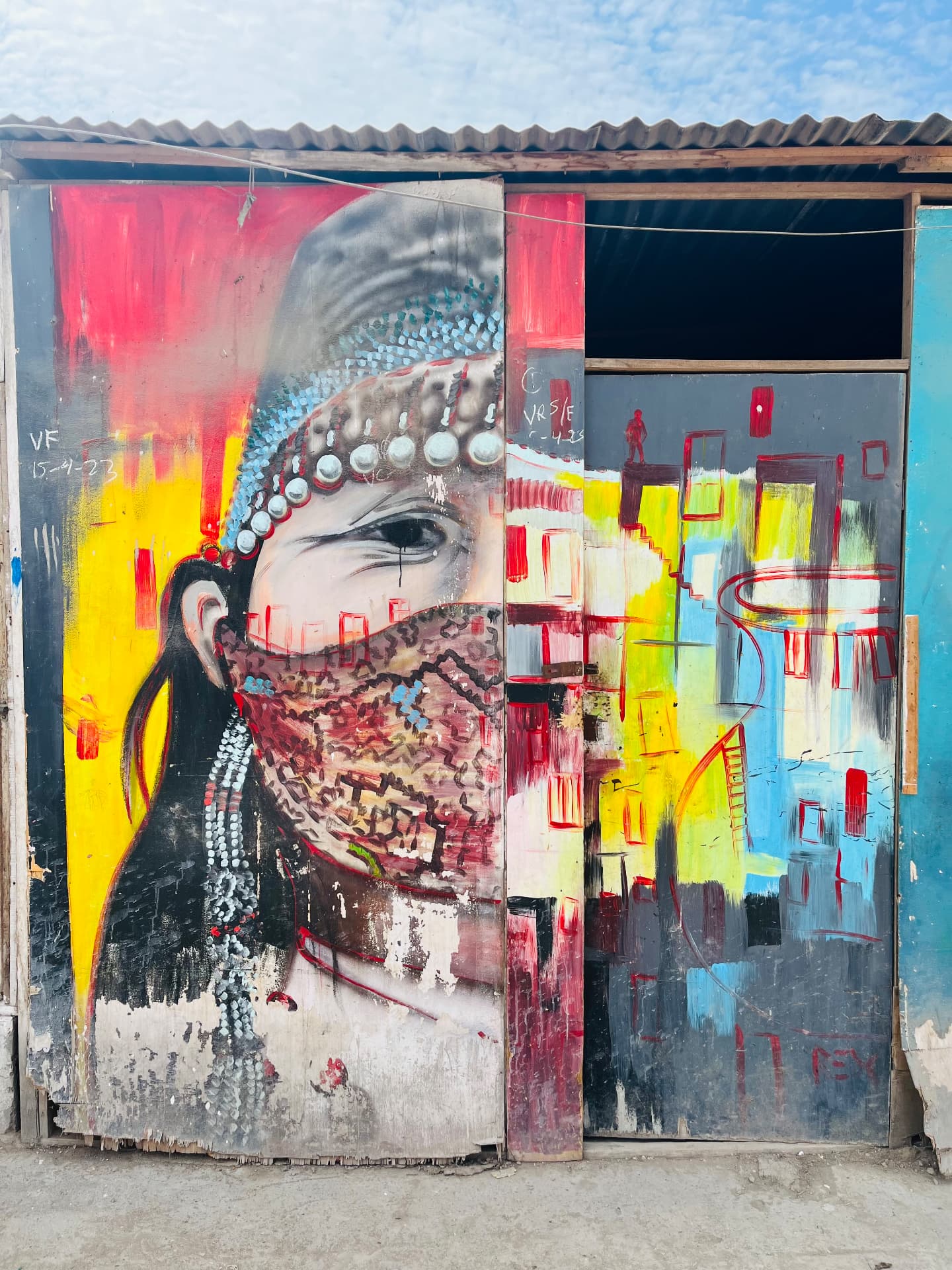 A street mural of a figure in beaded regalia